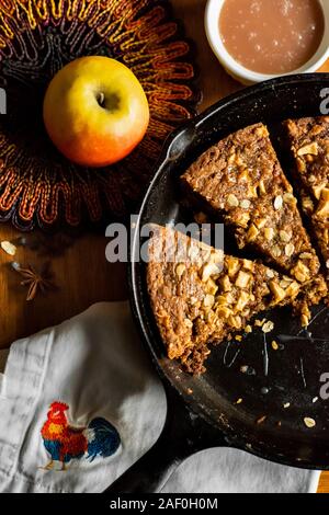 Mela caramellata dessert di avena all'interno di una padella in ghisa su un tavolo Foto Stock