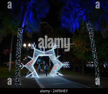 Un runner con nuove decorazioni vacanze a Lake Eola Park a Orlando in Florida. Foto Stock