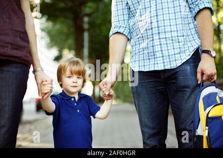 I genitori a piedi figlio a scuola materna o asilo nido Foto Stock