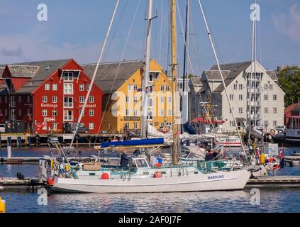 TROMSØ, Norvegia - Barca a vela ormeggiata al porto e colorato vecchi edifici in legno sul lungomare. Foto Stock