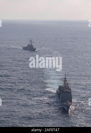 191129-N-OI558-1843 Mar Cinese Orientale (nov. 29, 2019) Il Arleigh Burke-class guidato-missile destroyer USS Barry (DDG 52), sinistra, vele in formazione con il Ticonderoga-class guidato-missili cruiser USS Shiloh (CG 67) durante un esercizio di manovra alla superficie di supporto del gruppo di azione delle operazioni. Shiloh è distribuita negli Stati Uniti 7 flotta area di operazioni a sostegno della sicurezza e della stabilità nella regione Indo-Pacifico. (U.S. Foto di Marina di Massa lo specialista di comunicazione di terza classe Chanel L. Turner) Foto Stock