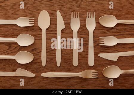 Vista superiore del legno Cucchiai Forchette e coltelli su sfondo marrone Foto Stock