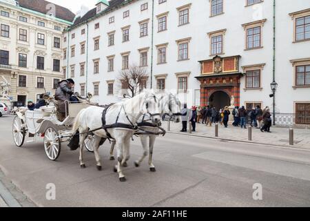 Cavallo e carrozza Vienna; turisti in un tour a cavallo e in carrozza intorno all'Hofburg, Vienna, Austria Europa Foto Stock