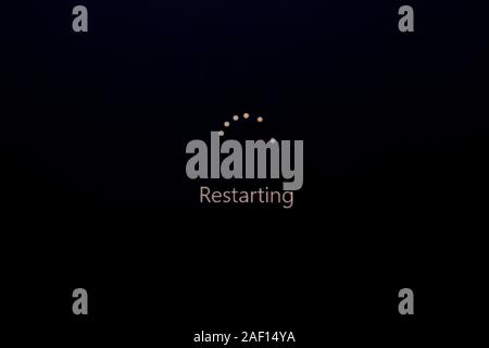 Windows Update del ciclo di filatura e 'Riavvio' sullo schermo del computer durante l'installazione Windows 10 aggiornamenti di sistema Foto Stock