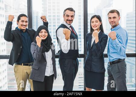 Ritratto di business gruppo di persone aventi fiduciosi nel successo del lavoro in ufficio moderno sfondo. Persone lifestyl e il partenariato collega concetto. T Foto Stock
