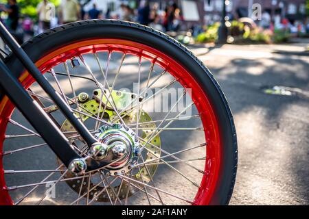 Ruota di moto di un vecchio vintage retrò bike permanente al tradizionale mostra all'aperto delle vecchie auto in un piccolo American città provinciale. Foto Stock