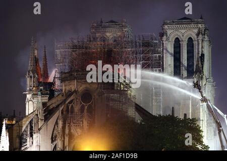 Parigi, Francia. 12 Dic, 2019. Vigili del fuoco battaglia per estinguere un incendio gigante che inghiottono Parigi' la Cattedrale di Notre Dame, il 16 aprile 2019. Il Presidente francese Emmanuel Macron giurò a ricostruire l'edificio del XIII secolo che accoglie decine di milioni di fedeli e turisti all'anno. Foto di Eco Clemente/UPI Credito: UPI/Alamy Live News Foto Stock