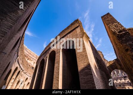 Le pareti e gli archi del Colosseo o il Colosseo, un anfiteatro ovale nel centro della città, visto dall'interno Foto Stock