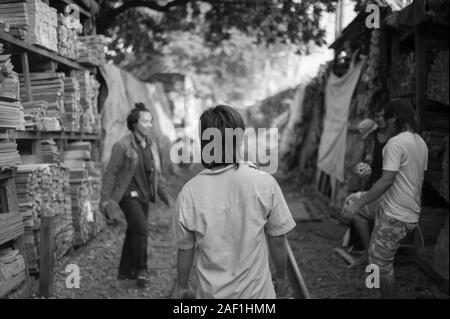 Bangkok, Tailandia - 23 dicembre 2010: Giovani falegnami sul break giocando a calcio kick-ups sulla linea ferroviaria di 70rai baraccopoli, la zona più povera di Bangkok Foto Stock