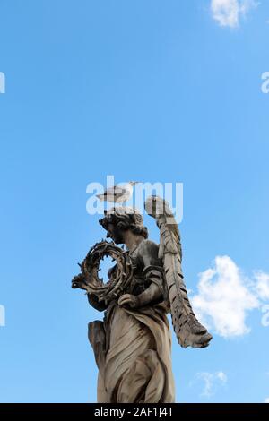 Angelo Che Porta la Corona Di Spine di Gian Lorenzo Bernini e un teschio si ergono sulla statua superiore di Castel Sant'Angelo, Roma, Italia Foto Stock