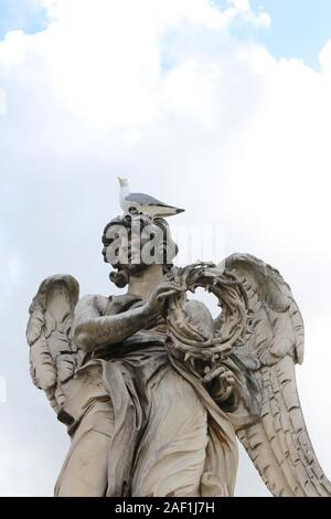 Angelo Che Porta la Corona Di Spine di Gian Lorenzo Bernini e un teschio si ergono sulla statua superiore di Castel Sant'Angelo, Roma, Italia Foto Stock