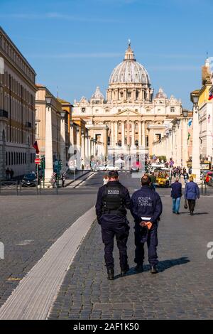 Due uomini di polizia a guardare la larga strada che conduce a Piazza San Pietro e la Basilica Papale di San Pietro, Basilica di San Pietro Foto Stock