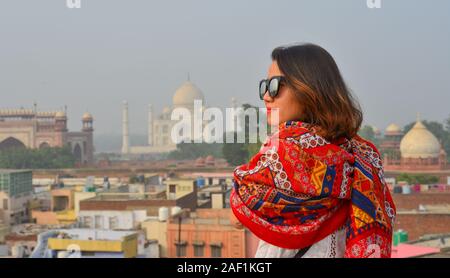 Una giovane donna con Indian saree guardando al Taj Mahal di Agra, India. Foto Stock