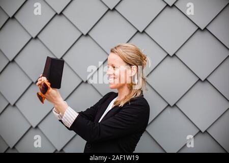 Donna sorridente tenendo selfie Foto Stock
