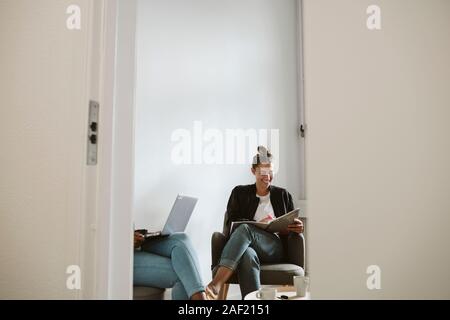 Donna sorridente iscritto nel notebook Foto Stock