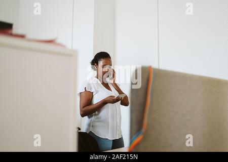 Donna al telefono in ufficio Foto Stock