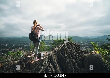 Turista femminile prende foto di sulla sommità del Monte Phousi a Luang Prabang, Laos Foto Stock