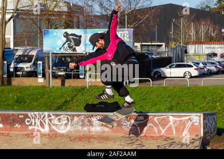 Giovane uomo imbarco a Radlands Skate Park, metà prato estivo, Northampton, Regno Unito. Foto Stock