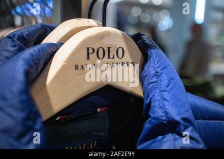 Cappotti invernali da designer di lusso etichetta di Polo Ralph Lauren appesi su una rotaia di vestiti in un negozio. Foto Stock