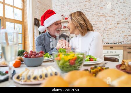 Allegro persone mature per celebrare il Natale a casa Foto Stock