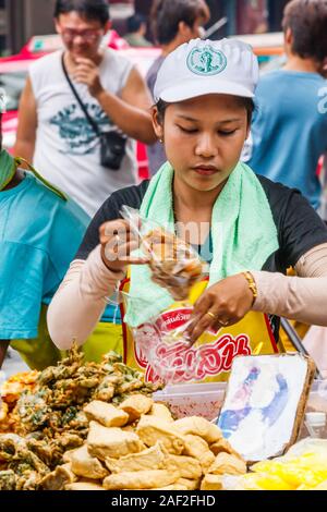 Bangkok, Tailandia - 26 Ottobre 2013: uomo vendita di succo di melograno formano un carrello mobile in Chinatown. Questa è una bevanda popolare in stagione. Foto Stock