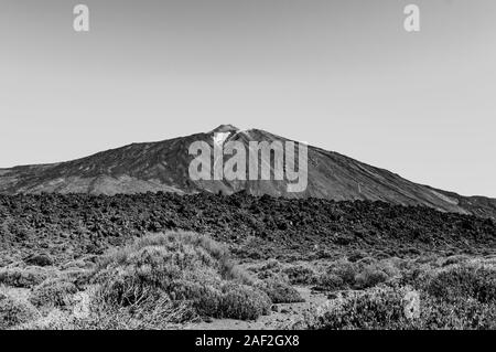 Bianco e Nero Shot del picco più alto dietro le zone aride rocce laviche su una soleggiata e molto chiaro giorno In El Parco Nazionale del Teide. Aprile 13, 2019. Santa Cruz De dieci Foto Stock