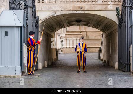 Due membri della Guardia Svizzera Pontificia in uniforme sono a guardia di un cancello all'interno del Vaticano Foto Stock