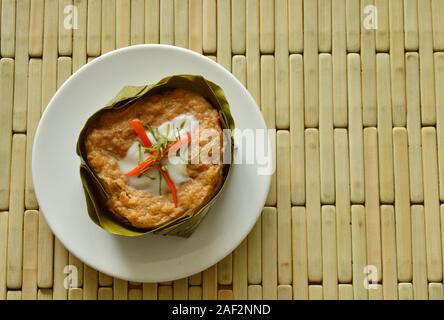 Pesce al vapore con pasta di curry indiano ripiene mulberry in latte di cocco sulla banana leaf cup Foto Stock