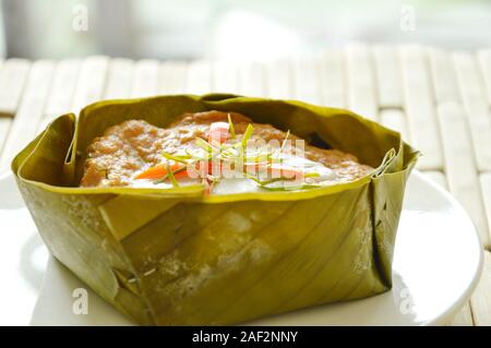 Pesce al vapore con pasta di curry indiano ripiene mulberry in latte di cocco sulla banana leaf cup Foto Stock