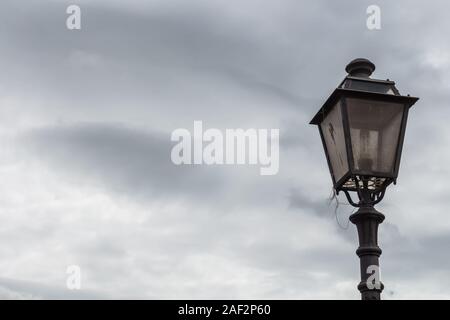 Classic - Lampada Lanterna sul palo sulla strada. Cielo Molto nuvoloso in background. Bosa, Sardegna, Italia. Foto Stock