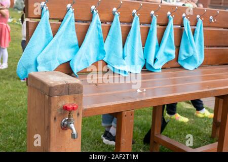 Molti asciugamani appesi su ganci vicino a una strada di lavabo in legno Foto Stock