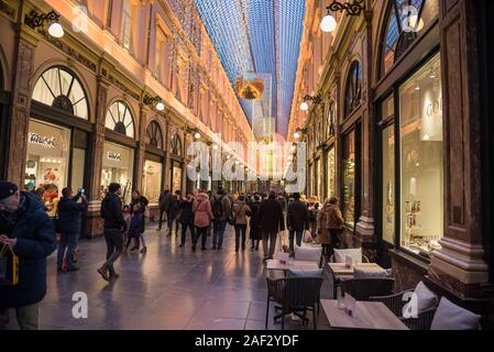 La folla di gente che passeggia lungo il famoso Royal Gallerie di Saint Hubert decorato per il Natale nel centro di Bruxelles Foto Stock