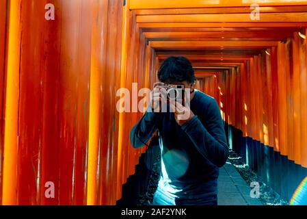 Uomo di scattare foto a Fushimi Inari Santuario. Kyoto, Giappone Foto Stock
