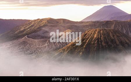 Vista da sopra, splendida vista ravvicinata del Monte Bromo crater e il Monte Batok circondato da nuvole durante il sunrise. Foto Stock