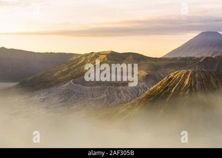 Vista da sopra, splendida vista ravvicinata del Monte Bromo crater e il Monte Batok circondato da nuvole durante il sunrise. Foto Stock