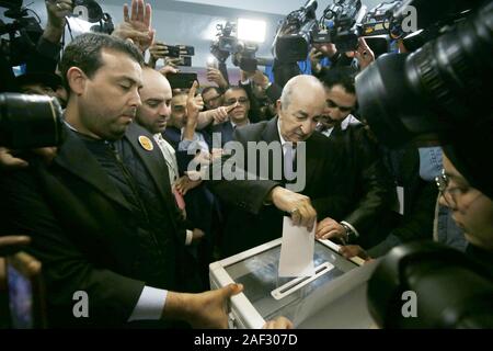 Algeri. 12 Dic, 2019. Algerino candidato presidenziale Abdelmadjid Tebboune (C) getta il suo voto in corrispondenza di una stazione di polling in Algeri, Algeria il 12 dicembre, 2019. Algeria tenuto elezioni presidenziali di giovedì. Un totale di cinque candidati sono in lizza per la presidenza per un periodo di cinque anni. Se nessun candidato ottiene la maggioranza assoluta dei voti in questo round, un secondo round si terrà dopo l annuncio dei risultati finali del primo round. Credito: Xinhua/Alamy Live News Foto Stock