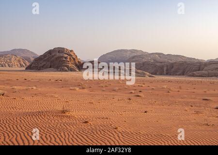 Scenario desertico. Sabbia rossa altopiano ai piedi delle montagne di Edom, Giordania Foto Stock