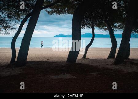 Donna correre sulla spiaggia di mattina anche in condizioni di tempo piovoso. Motivazione sport photo Foto Stock