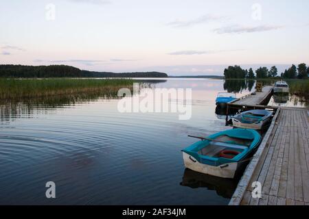 Calma sera d'estate al Lago di foresta con barche ormeggiate Foto Stock