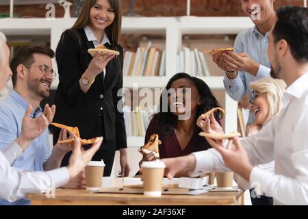 Età di diversa etnia colleghi mangiare pizza durante il pranzo presso i giorni lavorativi Foto Stock