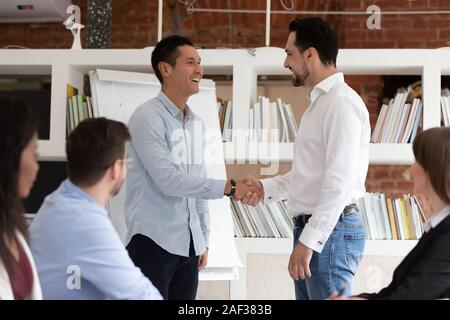 Medio Oriente boss stringono le mani con subordinate dipendenti asiatici Foto Stock