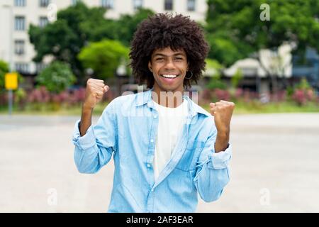 Il tifo african american hipster giovane adulto all'aperto in estate in città Foto Stock