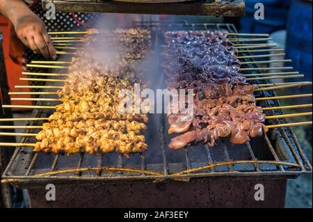 Spiedini di pollo e fegato di pollo sulla griglia calda, tailandese popolari street food. Foto Stock