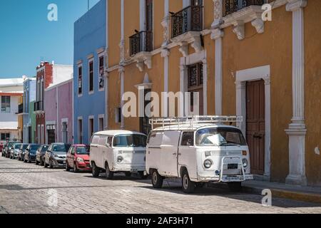 Due vecchie Volkswagen - stile furgoni parcheggiati su una delle vivaci strade della città coloniale di Campeche. Foto Stock