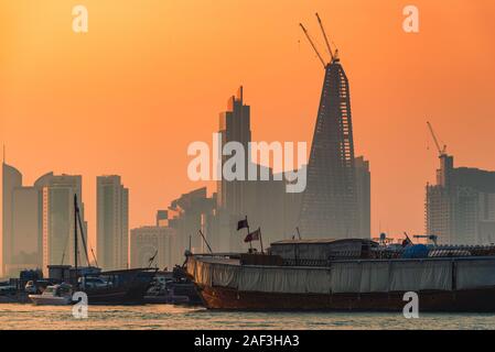 Il sambuco tradizionale barche della Qataris stand contro il moderno skyline di Doha, in Qatar. Foto Stock