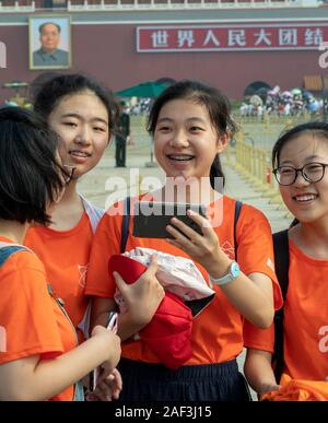 Scolari tenendo selfies su sulla gita da piazza Tiananmen e dalla Città Proibita di Pechino, Cina Foto Stock