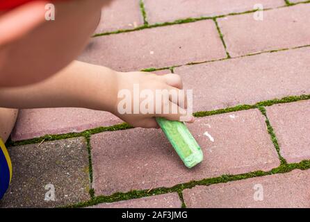 Piccole vernici per bambini con gesso sul marciapiede Foto Stock