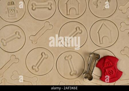 Vista superiore di pasta cruda con cookie cutter per in casa cane tratta in forma di ossa Foto Stock