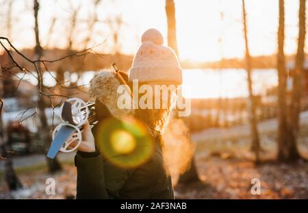 Ritratto di una donna sorridente tenendo gli sci al tramonto Foto Stock