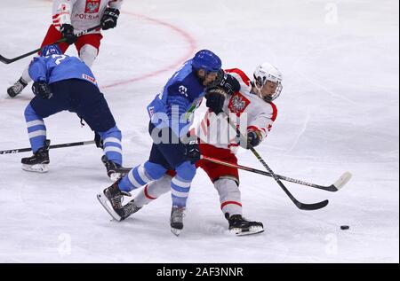 Kiev, Ucraina - 12 dicembre 2019: Massimiliano SOELVA d'Italia (L) si batte per un puck con Jakub LEWANDOWSKI della Polonia durante la loro 2020 IIHF Hockey su Ghiaccio Foto Stock